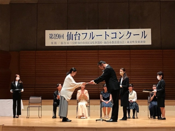 高校生部門第1位の戸田紗矢香さんに、高橋聖純先生より賞状・賞金・賞品の授与。